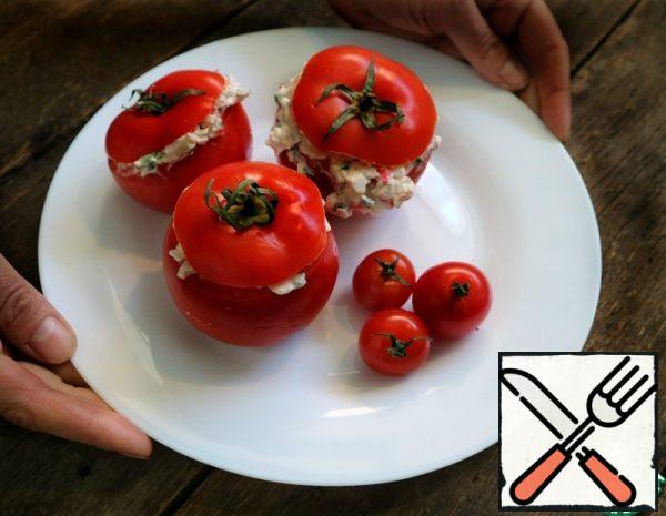 Cut off the tops of tomatoes and remove the pulp. Do not put the tops aside. Chop the green onions and crab sticks. Mix with cream cheese and salt. Fill the tomatoes and cover with the tops.