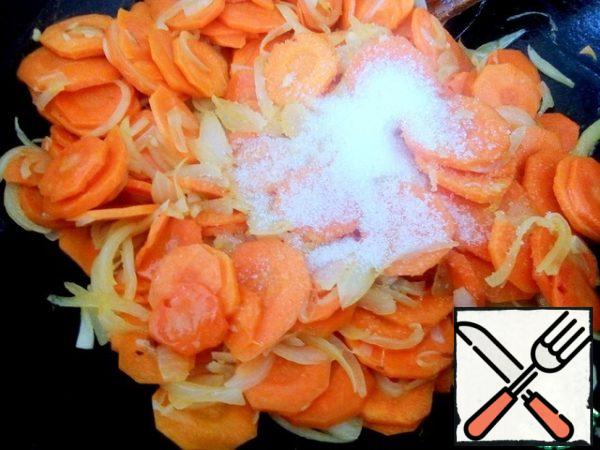 Add sugar, stir and continue to simmer for five minutes, stirring so that the carrots absorb the sugar.