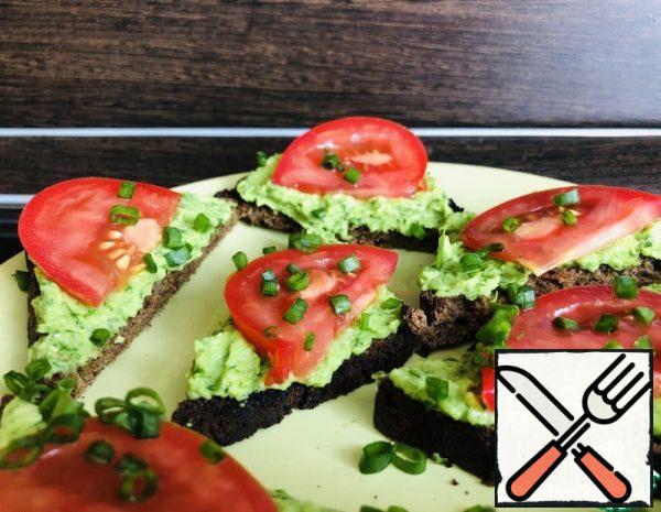 1. add the avocado pulp, parsley, garlic, lemon juice, olive oil, and salt to the blender bowl and mix well.
2. Pieces of Borodino bread are dried in a toaster.
3. spread the avocado paste on a slice of bread, spread the sliced tomatoes on top of the paste. Garnish with green onions.