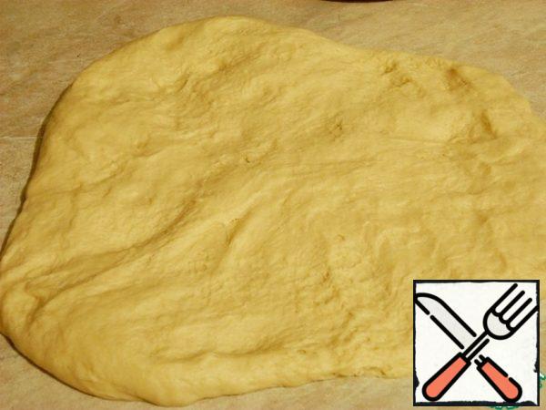 Put on a greased work surface, continue to knead - pull into the layer, roll and repeat several times.