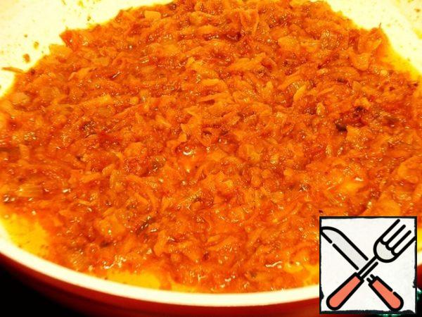 Cut the onion into cubes, put it in a deep frying pan or saucepan with heated vegetable oil, and simmer over medium heat until transparent. Add grated carrots with large scales and simmer for 3-5 minutes. Add the tomato sauce, stir, and lightly fry.