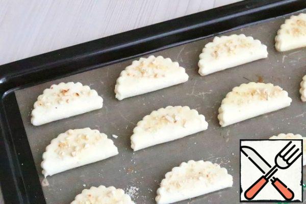 Sprinkle the surface of the cookie with crushed and fried almonds.
Send the baking tray with cookies to the oven preheated to 190*C, bake until Golden.
