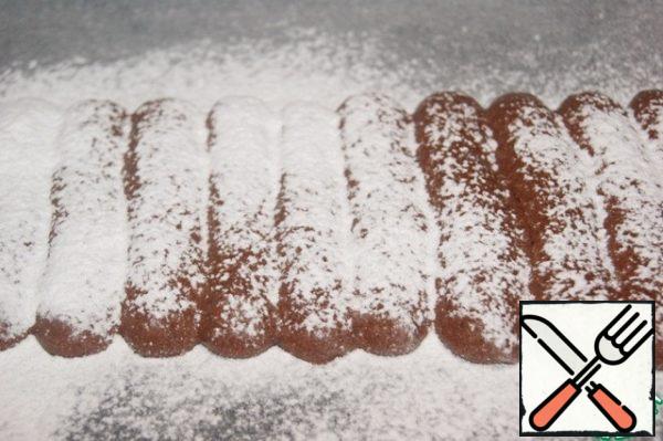 Through a fine sieve, sprinkle with powdered sugar, not as hard as I did. I had to sweep it away with a brush after baking.