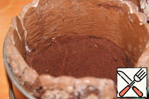 On the side of the form, put the sponge sticks, if they do not fit, cut off one or two, do not fasten the form, let it be wider. Down put a round sponge cake, it should lie very tightly, nothing if a little wrapped, the main thing is not to leak the cream.