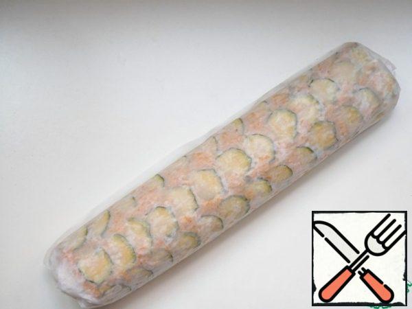 Remove the baking sheet from the oven and roll the cake, without removing it from the parchment, into a roll, cover with a towel.