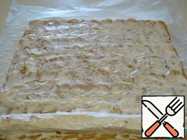 When the roll is slightly warm, unwrap it and carefully separate it from the paper, but leave it zucchini down.
Mix the curd cheese, if desired, you can add grated garlic, and grease the entire surface with a thin layer of cheese. Put the rest of the cheese "roller"along the wide edge.