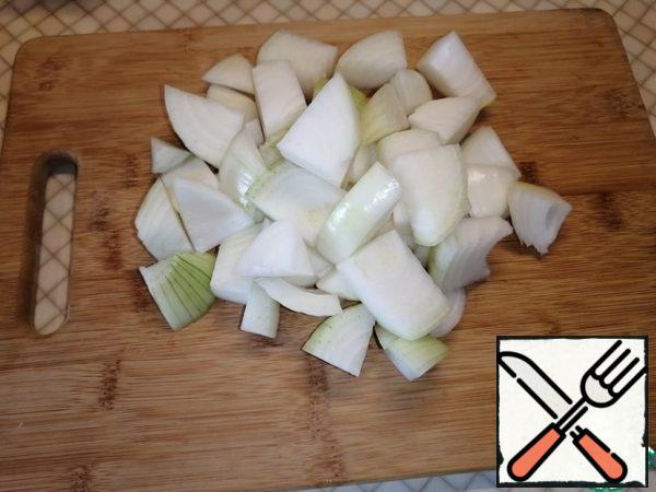 While the chicken is being fried, cut the onion into large cubes.