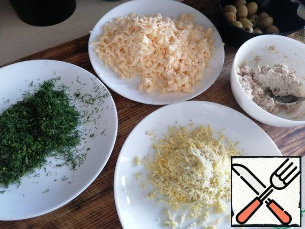 Grate the melted cheese, remove the white from the boiled eggs, and grate the yolk on a fine grater and sprinkle a little turmeric for an even greater yellow color (only be careful, turmeric is very strongly colored in yellow), punch the chicken cooked meat with a blender to turn it into minced meat and add 1 tsp mayonnaise for viscosity. From fennel to remove all the thick stems and finely chop only the dill sprigs.