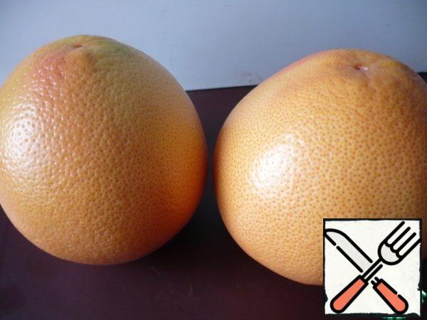To prepare the dessert, take two red grapefruits, wash and dry.