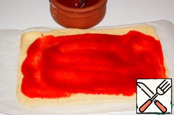 Remove the paper and spread a thin layer of jam. I have mashed strawberry puree 50 g, which I saddened with 6 g of gelfix, adding it to the puree and boil after boiling for 2 minutes.