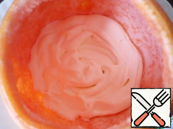 Using a pastry bag, spread the cream inside the grapefruit.