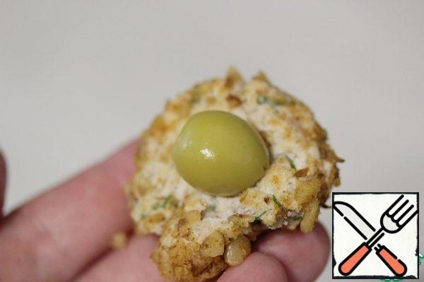 From a small amount of pate, make a flatbread, put an olive in the middle, roll a ball.