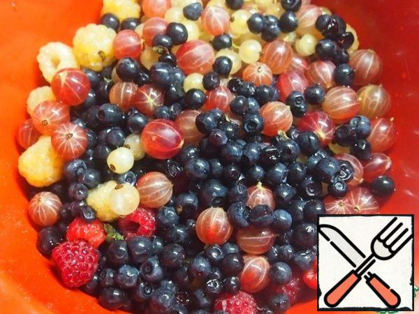 Sift flour and mix with baking powder. Add to the liquid ingredients and stir. If the dough is cool, add a couple of spoons of sour cream or kefir. In several steps, enter the proteins, stirring gently. Wash the berries. I have gooseberries, raspberries, currants and blueberries.