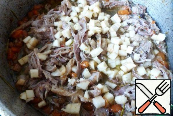 Remove the meat from the bones. Use two forks to break the meat into small pieces or fibers. Taste it, add salt or pepper if necessary. You can add a pinch of sugar to balance the flavor. Pull out the rosemary sprigs and ginger slices.
Add the Apple cubes and cook them until soft, about 20-30 minutes. They will give their taste and aroma to meat.