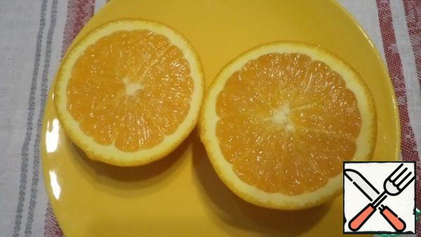 Wash the orange, dry it and cut it into 2 parts.