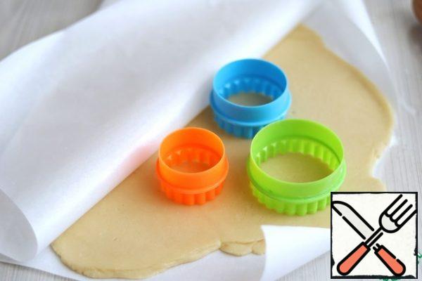 Roll out the shortbread dough between two sheets of parchment about 3-5 mm thick. To make a cake, you will need cuts for cookies equal in shape, but different in diameter. Only 3 PCs.