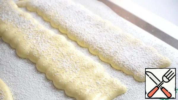 Sprinkle powdered sugar on top.
Place the baking sheet in the oven, preheated to 190°C. Bake the sponge cake for 10 minutes.