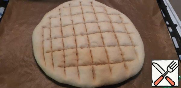 When the dough has come up, make cuts in the form of a grid half the height of the tortilla, so that the filling is soaked in Focaccia.