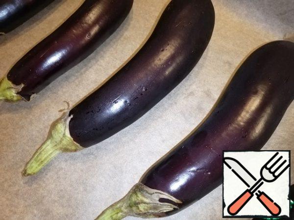 Heat the oven to 200°C. Cover the baking sheet with parchment. Arrange the washed eggplants. Make a few small punctures. And send in the oven until ready, it takes me 10-15 minutes. Focus on your oven.