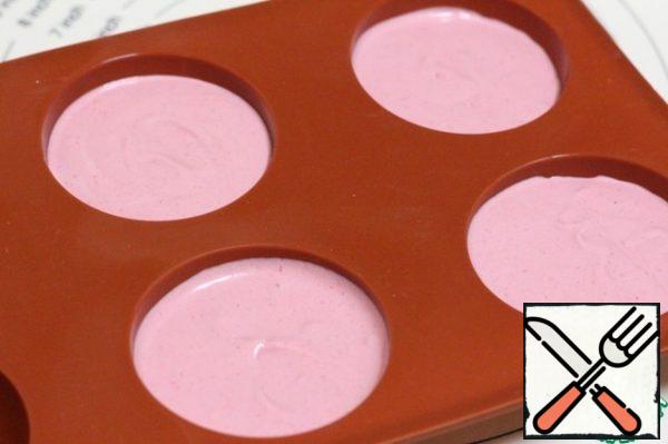 Silicone molds for mousse cakes with a diameter of 6 cm fill with raspberry mousse, retreating from the edge of 2 cm.
