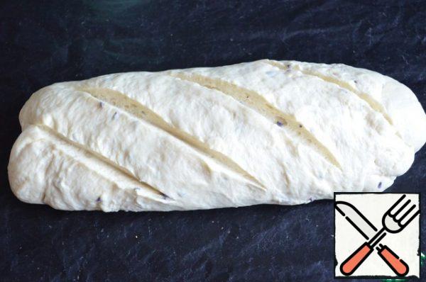 Knead the dough, form a blank of bread. Use a sharp blade to slice the dough.