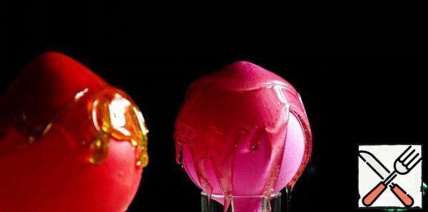 For our caramel cremans, if desired, we will add colorants, you can mix several and get patterns-divorces. Then quickly pour on pre-prepared balloons. We take high-quality balls, fill them with cold water so that there is some free space left. And we test for strength: we bring a lighted match, the ball should not burst)
Caramel hardens very quickly in the process - just warm it up again to a liquid state.
Pour the caramel on the balls from all sides, laying something for the glaze flowing down the walls of the ball.
For cremans in the form of shells and glasses, - dip the ball in caramel from all sides and hang it.
Leave the balls alone, the caramel should be fixed.