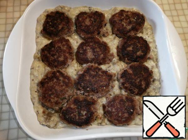 Put the eggplant puree in the baking dish and lay out the meatballs.