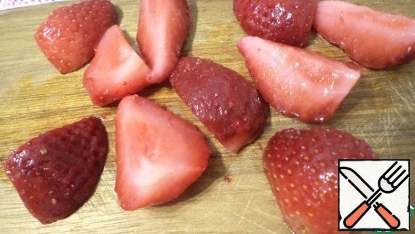 Cut the strawberries, if it is frozen, then pre-defrost it a little.