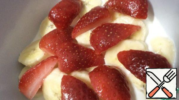 Cut the banana, pour cream and add strawberries