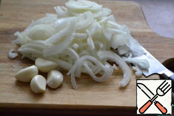 Cut the onion into half rings.
Peel the garlic.