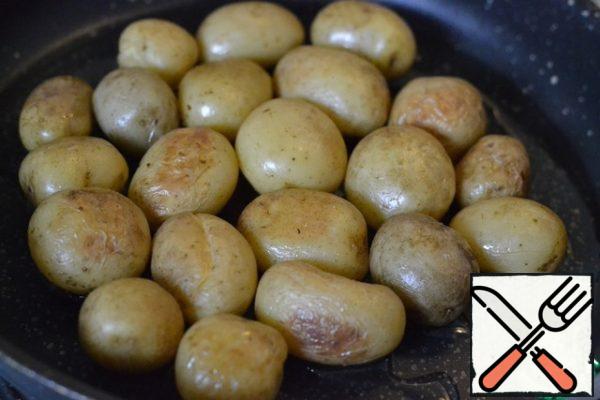Wash and boil the new potatoes until tender.
Heat 4 tablespoons of sunflower oil in the pan where the cake will be prepared.
Put the potatoes in the pan and lightly fry.