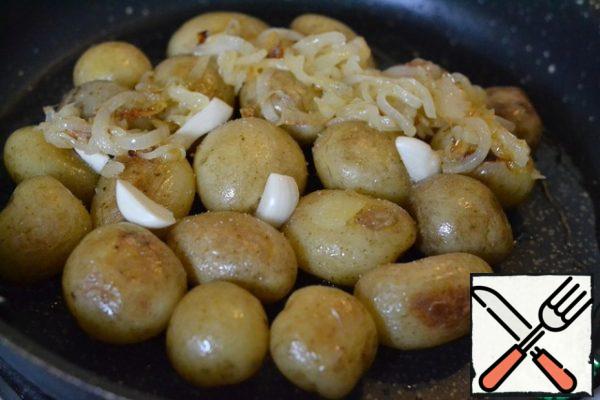Spread the garlic between the potatoes.
Spread the onion on top of the potatoes.
