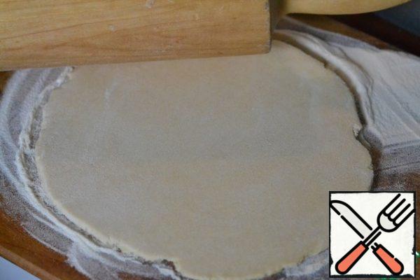 Sprinkle the cutting Board with flour.
Roll out the dough into a circle with a diameter that corresponds to the pan on which we will bake the tart.