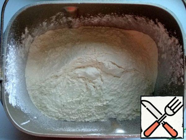 I will knead the dough in a bread maker. Pour the kefir into the bread maker bucket, add salt and soda, and sift the flour.