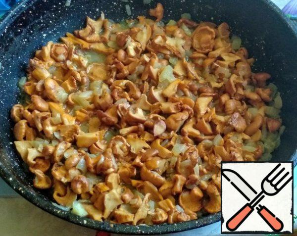 Next, wash the chanterelle mushrooms and cut them. Peel the onion, wash it and cut it into cubes. Fry the mushrooms and onions in olive oil until tender, about 10-15 minutes.