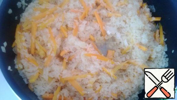 Add the rice to the onions and carrots and simmer over low heat for 5 to 8 minutes.