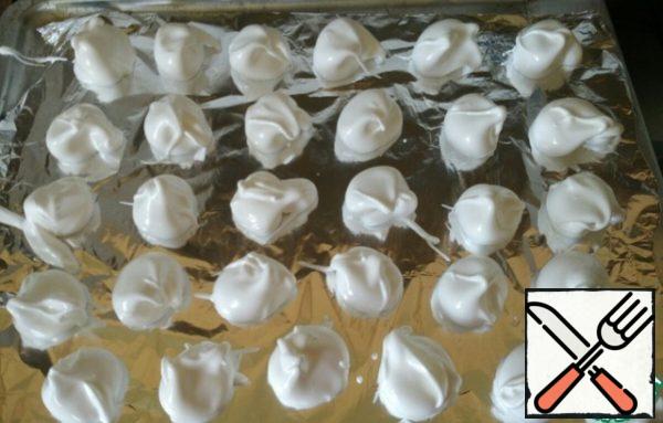 Cover the baking sheet with foil, carefully place small portions of cream with a teaspoon about 3 cm in diameter, at a distance of 1.5 cm from each other.