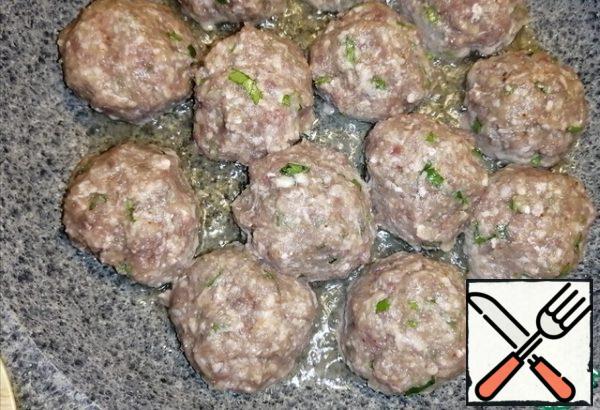 Make small meatballs with minced meat. Pour 2 tablespoons of vegetable oil into a preheated frying pan. And fry the meatballs on each side until a crust forms.