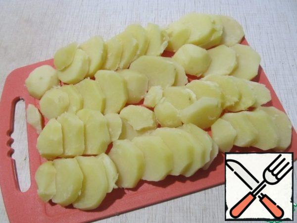 Peel the potatoes and boil them in salted water for 15 minutes.
Cut the cooked potatoes into slices.