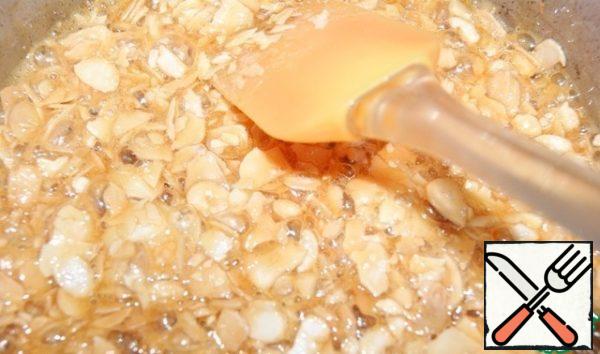 When the caramel gets its characteristic Golden color, pour in the almonds warmed in the microwave and stir well.