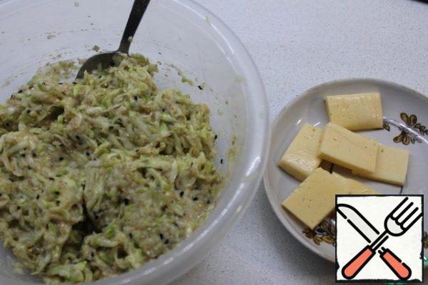 Mix the mass thoroughly.
Cut the cheese into small flat pieces.
