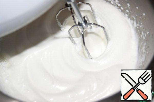 Without stopping to beat, switch the speed of the mixer to the lowest and add a spoonful of sugar.
Continue to beat, gradually adding sugar and increasing the speed of the mixer.