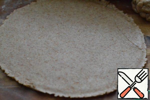 Cover the bottom of the baking dish (26cm) with baking paper.
Roll out the dough.
Cut a circle from the dough to fit the shape.
