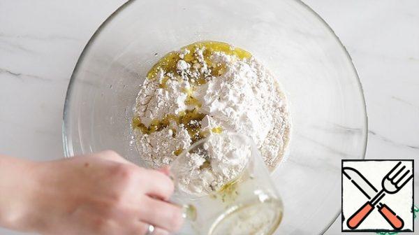 Add flour, salt and half of the cooled olive oil (35 ml). Mix everything well — you should get a very smooth, viscous dough.