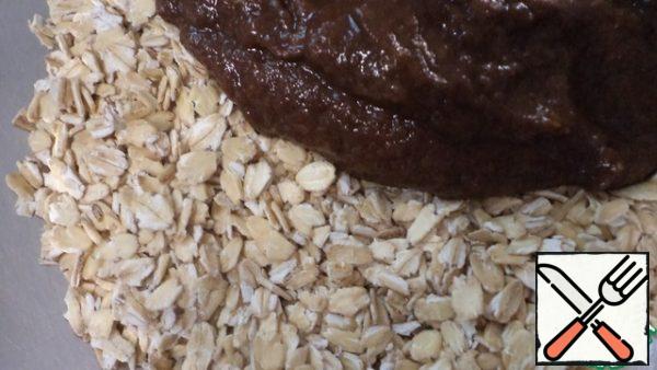 Punch the banana with a blender and add the cocoa, mix and transfer to a bowl with the flakes.