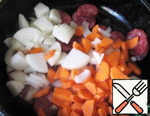 Add the chopped onions and carrots (cut all the vegetables into large pieces). Fry all together until the carrots are soft over medium heat, not forgetting to stir.