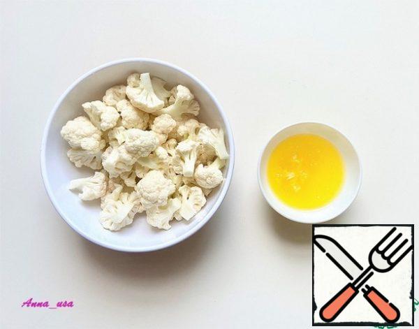 Wash the cauliflower, dry it with a paper towel and sort it into small inflorescences. Melt the butter, squeeze the garlic into it and stir.