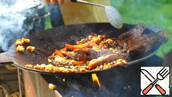 Fry the loin on both sides until a crust forms. Move to the edge of the saj, and put the potatoes in the lard.