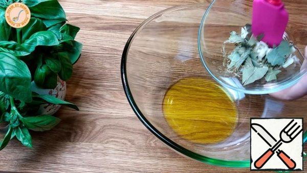 We begin to prepare the marinade. Take the garlic and cut it into small slices and put everything in a bowl. Add a few Bay leaves and a little dried rosemary.