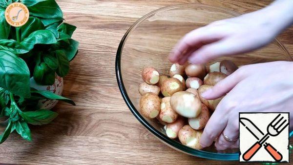 In a large container, pour the vegetable oil and add the garlic mixture, mix everything. Add salt and black pepper to taste. With this mixture, cover all the potatoes and leave for 5-10 minutes, so that the potatoes are completely soaked in all the spices.